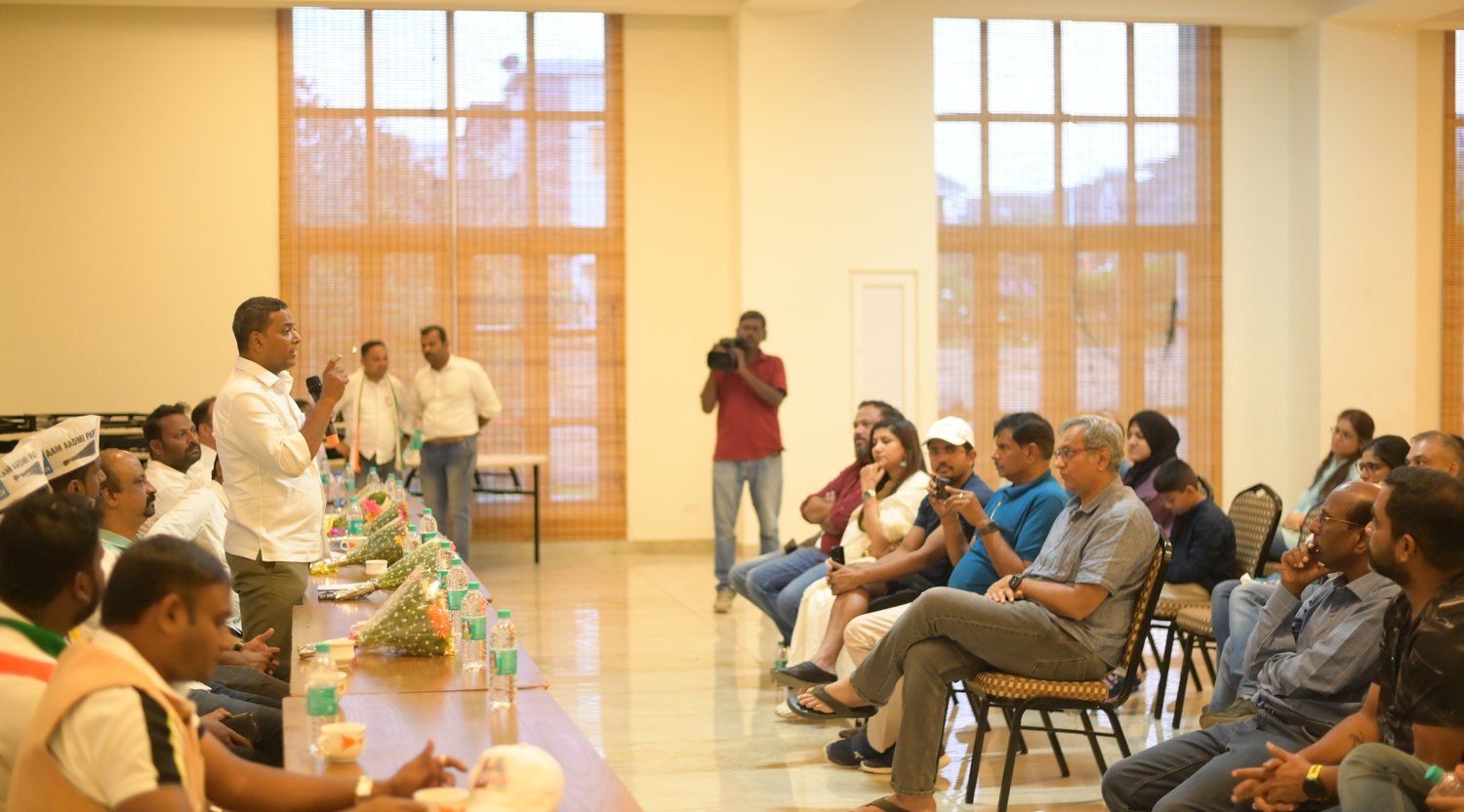 Mansoor Ali Khan speaking with residents at a public meeting.