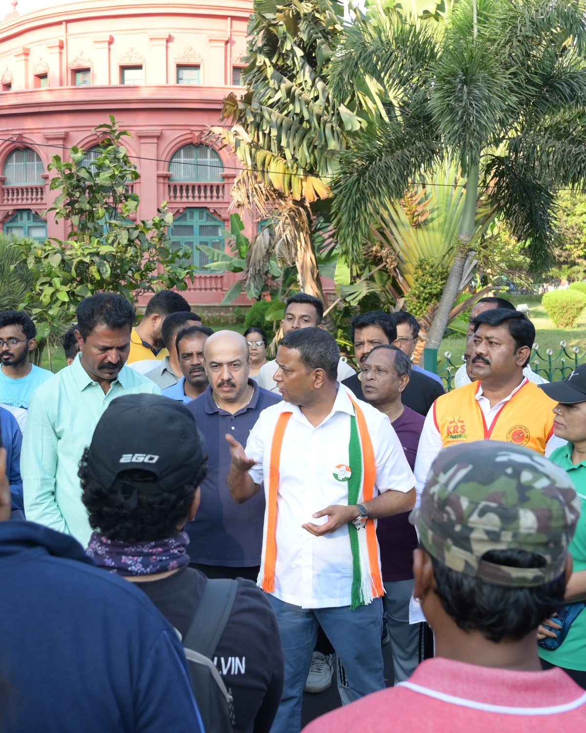 Mansoor Ali Khan speaking with residents at a morning gathering in Bengaluru, the State Central Library behind him.